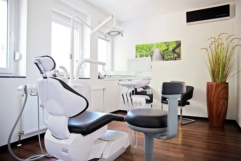 Helles Behandlungszimmer der Zahnarztpraxis Dr. Kelterbaum in Gelsenkirchen mit modernem Behandlungsstuhl